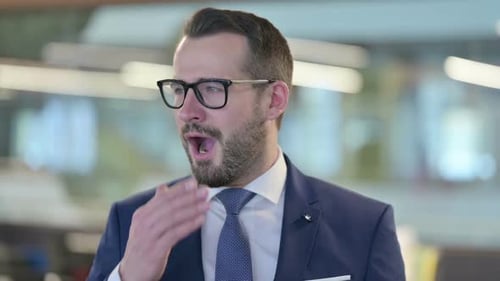 Porträt eines verschlafenen Geschäftsmannes mittleren Alters beim Gähnen
