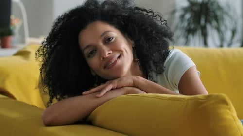 Woman Smiling on Couch at Home Indoors