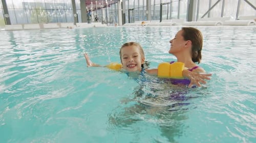 Frau mit Tochter im Pool