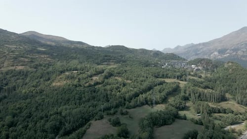 Aerial View Over the Lush Green Vegetation on the Mountainous Terrain and a Small Hamlet By the Side