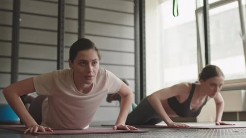 Women Exercising Together Doing Pushups in Gym