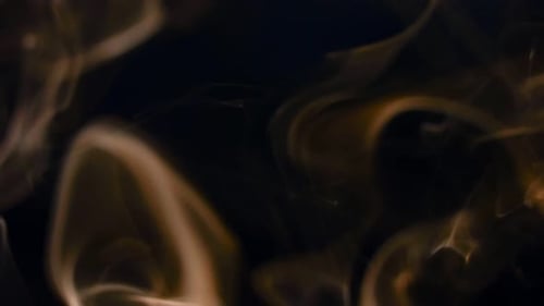 Golden Smoke Curls Against Black Background