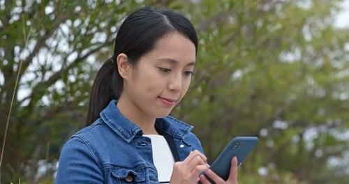 Woman use of mobile phone at the park