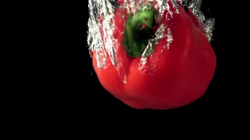 Super Slow Motion Red Bell Pepper Falls Under the Water with Air Bubbles