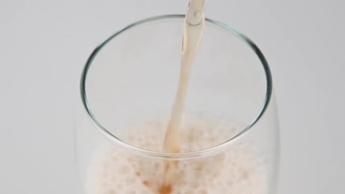 Pale Beverage Being Poured into a Glass