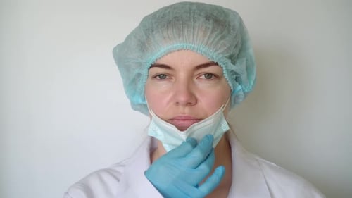 Health Worker Adjusts Surgical Mask Close Up
