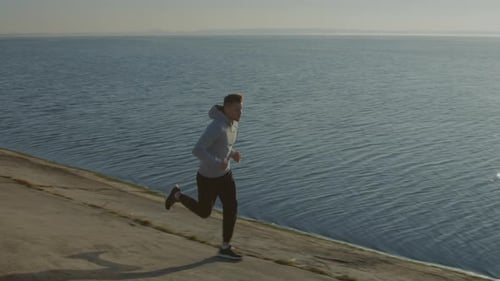 Man Running by the Ocean at Sunrise