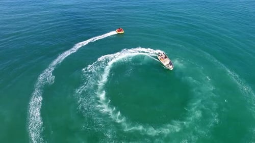 Aerial View of Motorboat Pulling Raft on Tropical Ocean