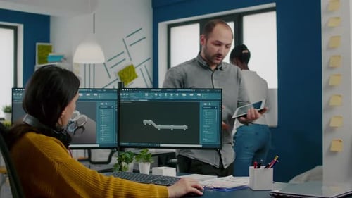 Designer industriel discutant avec un collègue tenant une tablette