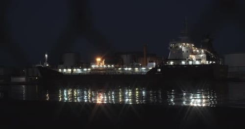 Bright Lights From the Port and Large Ship Reflecting on the Dock's Oceanside