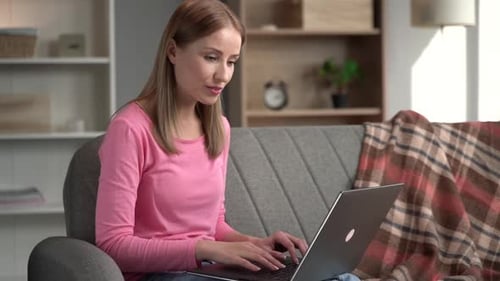 Woman Works on Laptop Computer at Home