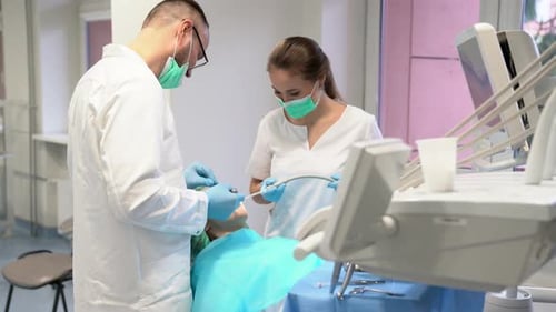 Dentist and Assistant Performing Dental Procedure on Patient