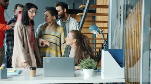 Excited Team Celebrates Success at Office Laptop