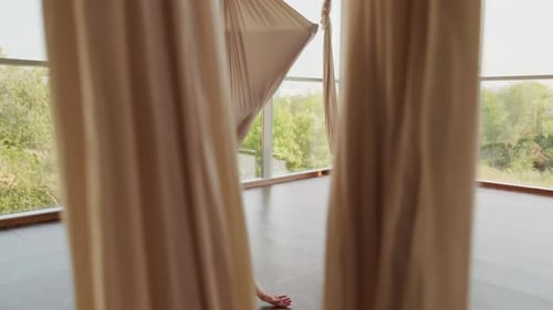 Young Women Doing Aerial Yoga Poses in Studio