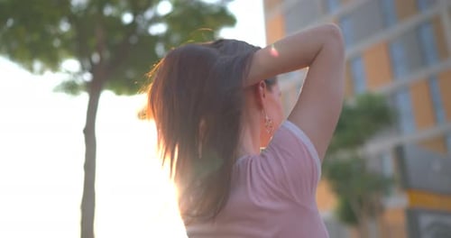 Young Woman Playing with Hair in the Park