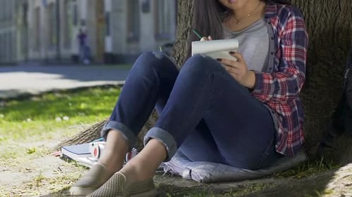Studentin konzentriert sich auf Wissen und Gedanken, schreibt Essay im Notizbuch