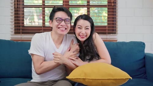 Excited Couple Watching TV on Couch Indoors