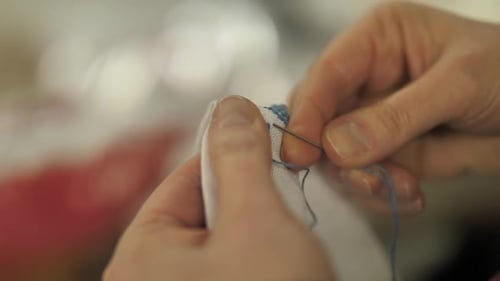 Close Up of Hands Sewing with Needle and Thread