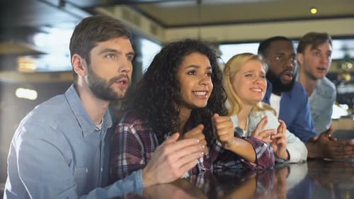 Friends Cheering at Bar Watching Sports