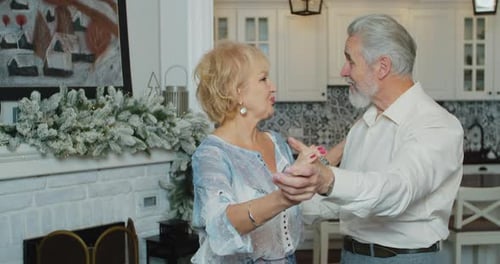 Close Up Shot of Cheerful Senior Woman Dancing with Husband in Front of Christmas Decorated