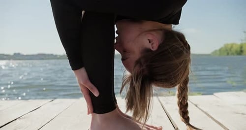 Young Blonde Woman Practicing Yoga on the Wooden Berth at Lake. Single Sport Healthy Training on