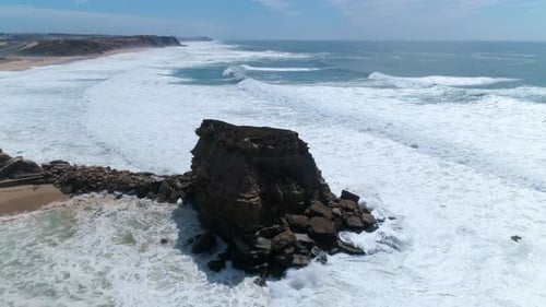 Aerial View of Waves Crashing on Rocky Beach