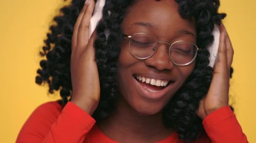 Smiling Young Adult with Headphones Listening to Music