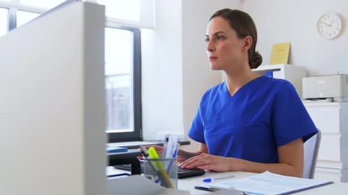 Doctor or Nurse with Computer Working at Hospital