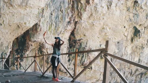 Touriste prenant une photo de selfie avec son smartphone alors qu'elle était en vacances dans la grotte de Devetashka, Lovech