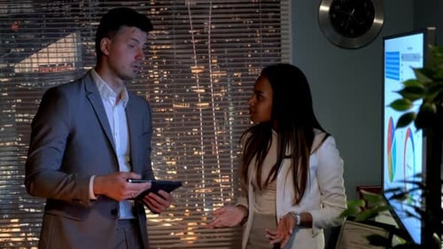 Business Professionals Discussing Data At Night