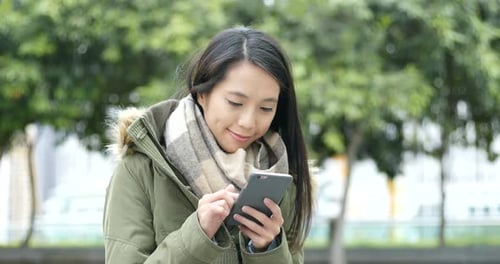 Woman Using Smartphone in City Park