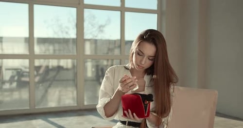 Beautiful Girl Doing Makeup with a Brush in Studio