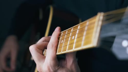 Experienced Artist Plays Acoustic Guitar Using Barre Chords