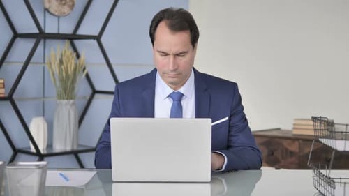 Businessman Working on Laptop in Office