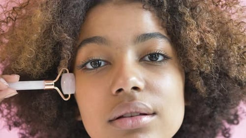 Woman Using Facial Roller for Beauty Treatment