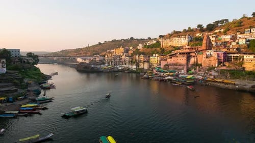 Time lapse: Omkareshwar cityscape, India, sacred hindu temple. Holy Narmada River, boats floating