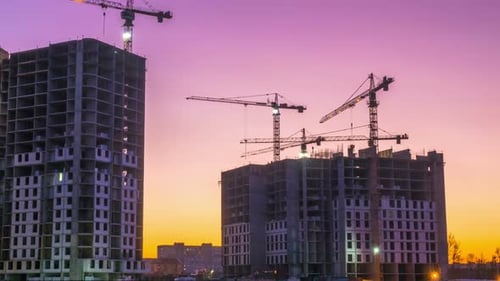 Buildings Under Construction at Sunset With Cranes