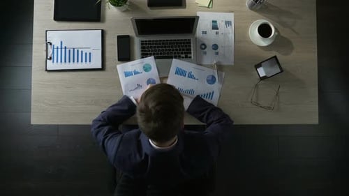 Homme d'affaires triste assis à table et pensant aux dettes Faillite Vue de dessus