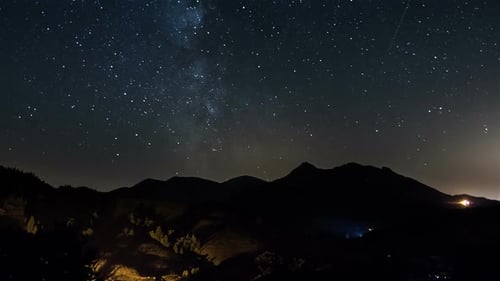 Estrellas moviéndose en el cielo nocturno sobre montañas en el campo. Astronomía de la Vía Láctea