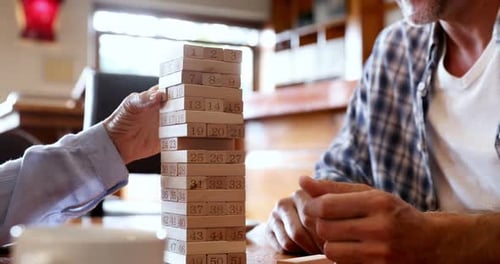 Mid section of friends playing jenga 4k