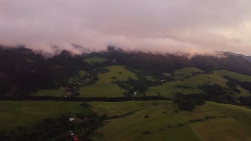 Aerial view , Hilly rural landscape after a storm shrouded in clouds at dusk in the golden hour.