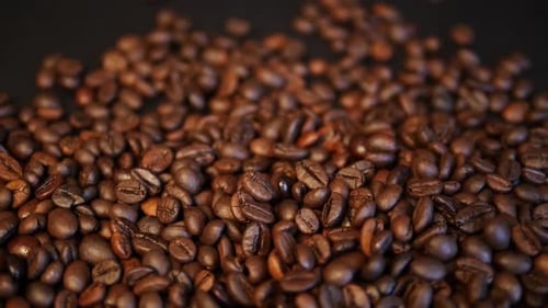 Geröstete Kaffeebohnen auf schwarzem Hintergrund. Kaffee-Nahaufnahme.