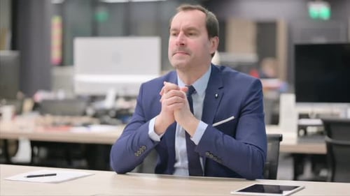 Upset Businessman Feeling Worried While Sitting in Office