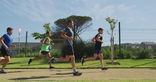 Men running outside on sunny day