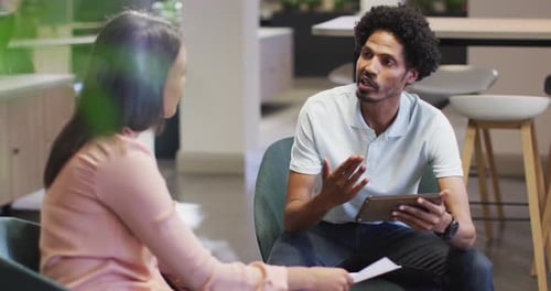 Man and Woman Discuss Work in Modern Office