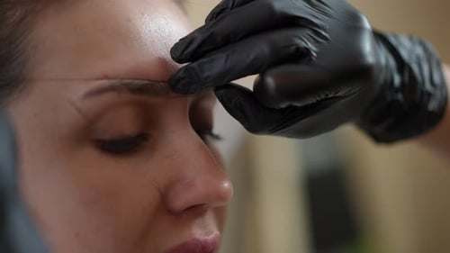 Nahaufnahme Shaping Augenbrauen für Permanent Makeup im Schönheitssalon