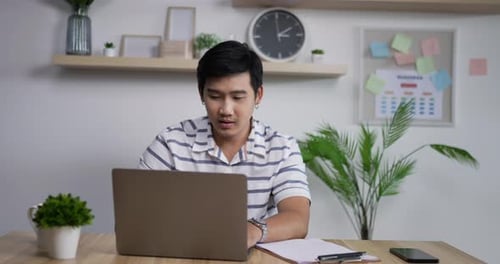 Young Adult Working on Laptop at Desk