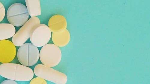 Blue White and Yellow Pills on Blue Background