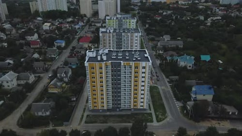 City block. Modern multi-storey buildings among cottages.