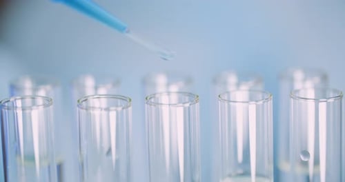 Extreme Close Up of Pipette Dropping Water Into Sample Tube at Laboratory